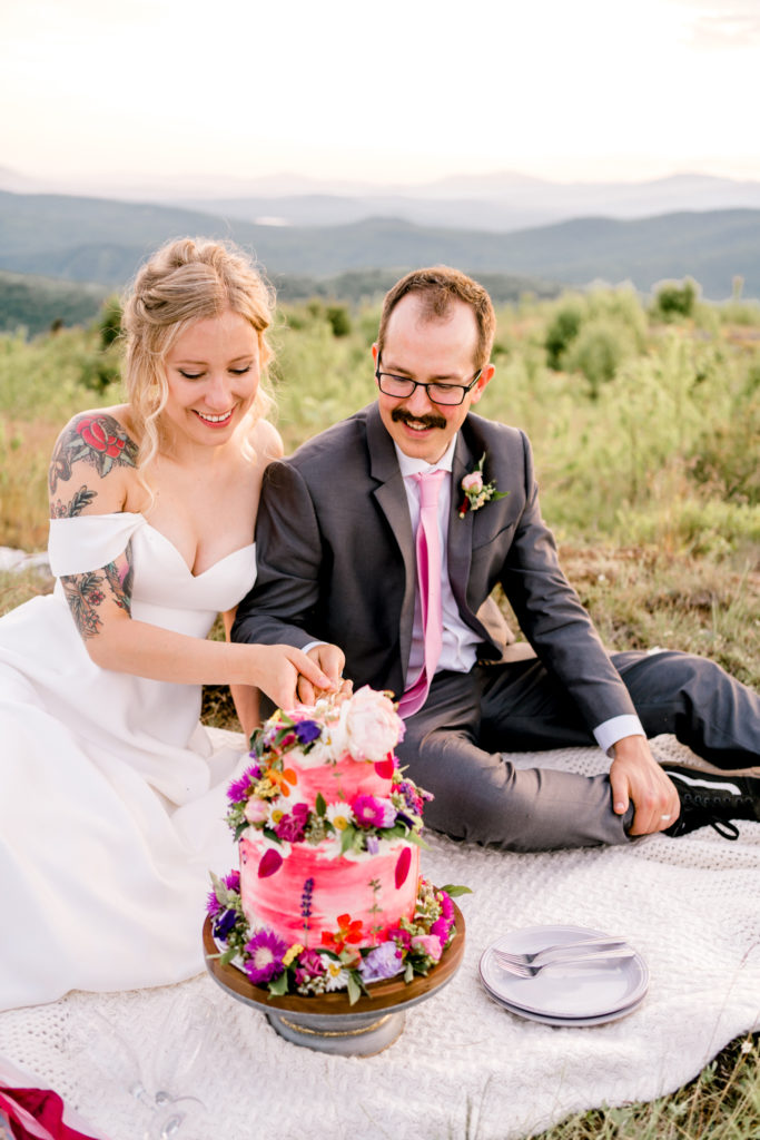 A newlywed couple enjoys a picnic on a mountain during their Maine elopement.