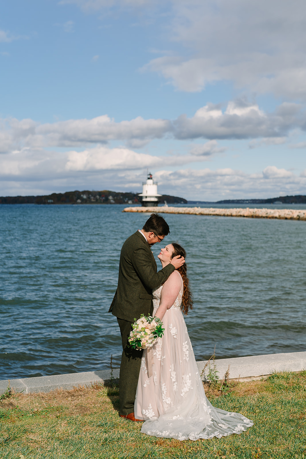 A couple standing in front of the ocean while eloping on the Midcoast of Maine.